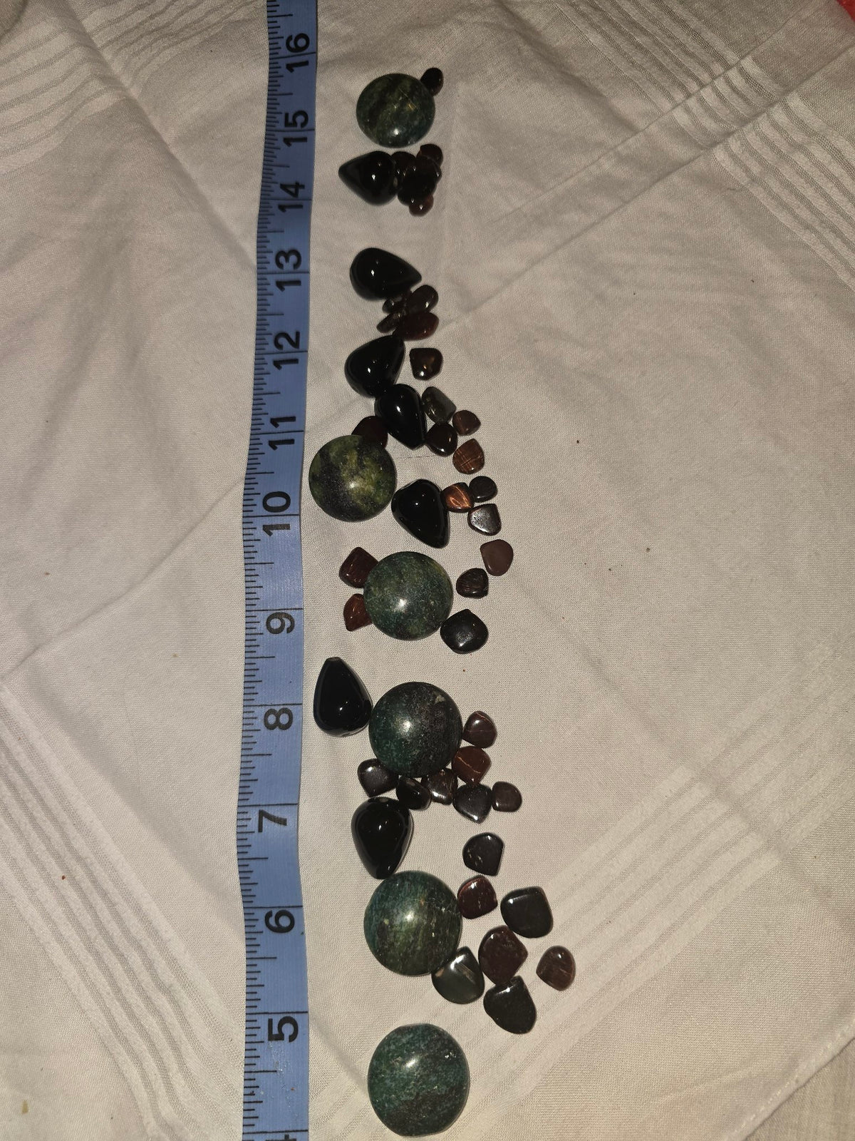 Mixed loose gemstone lot, large green jasper rounds, black onyx teardrops, small chips, with ruler for scale