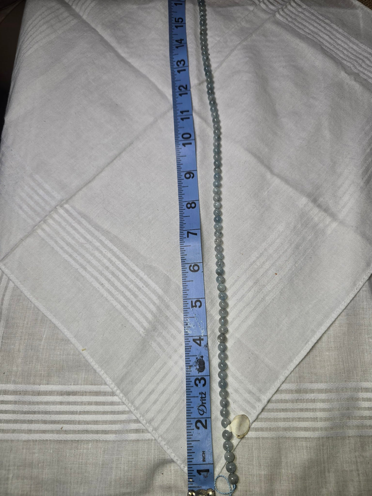 Aquamarine round bead strand with ruler for scale