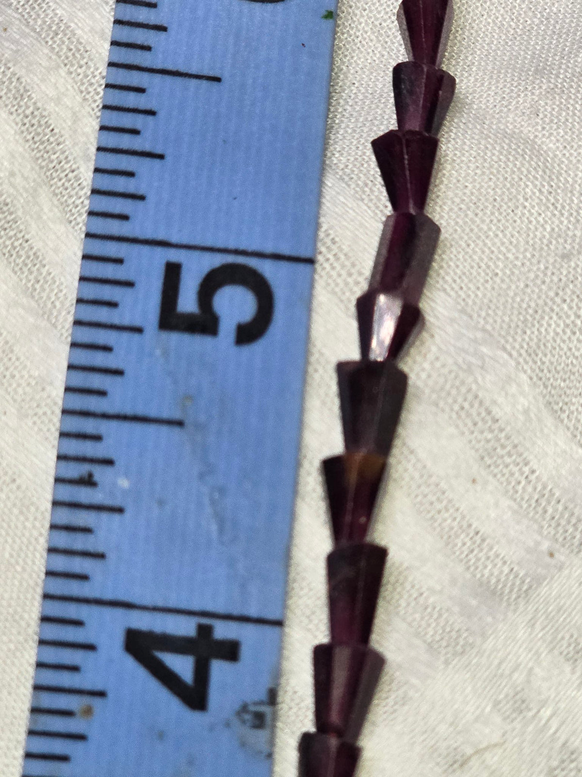 Dark purple faceted cone beads closeup