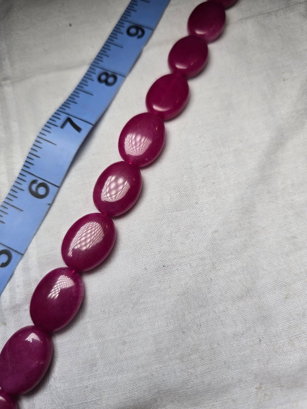Magenta pink oval bead strand closeup