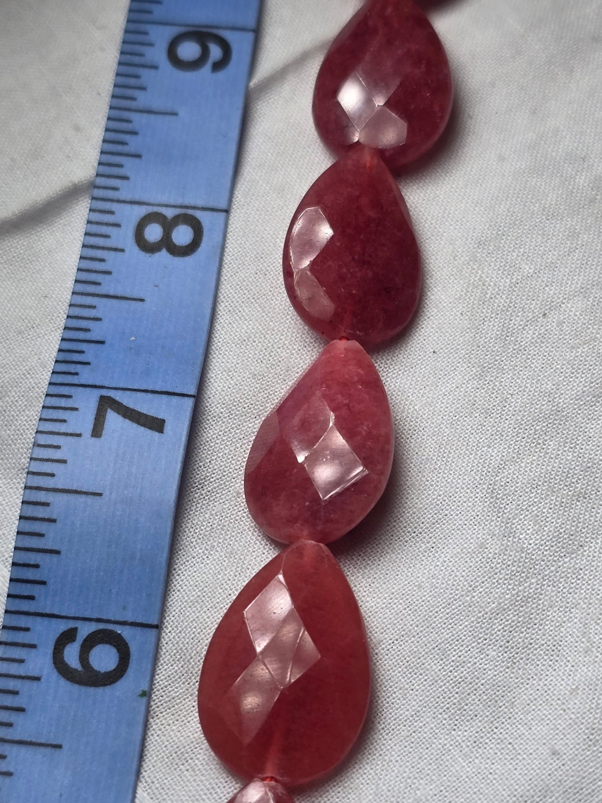Red pink faceted teardrop bead strand closeup