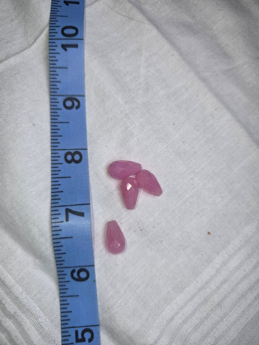 Four light pink faceted teardrop drop beads with ruler for scale