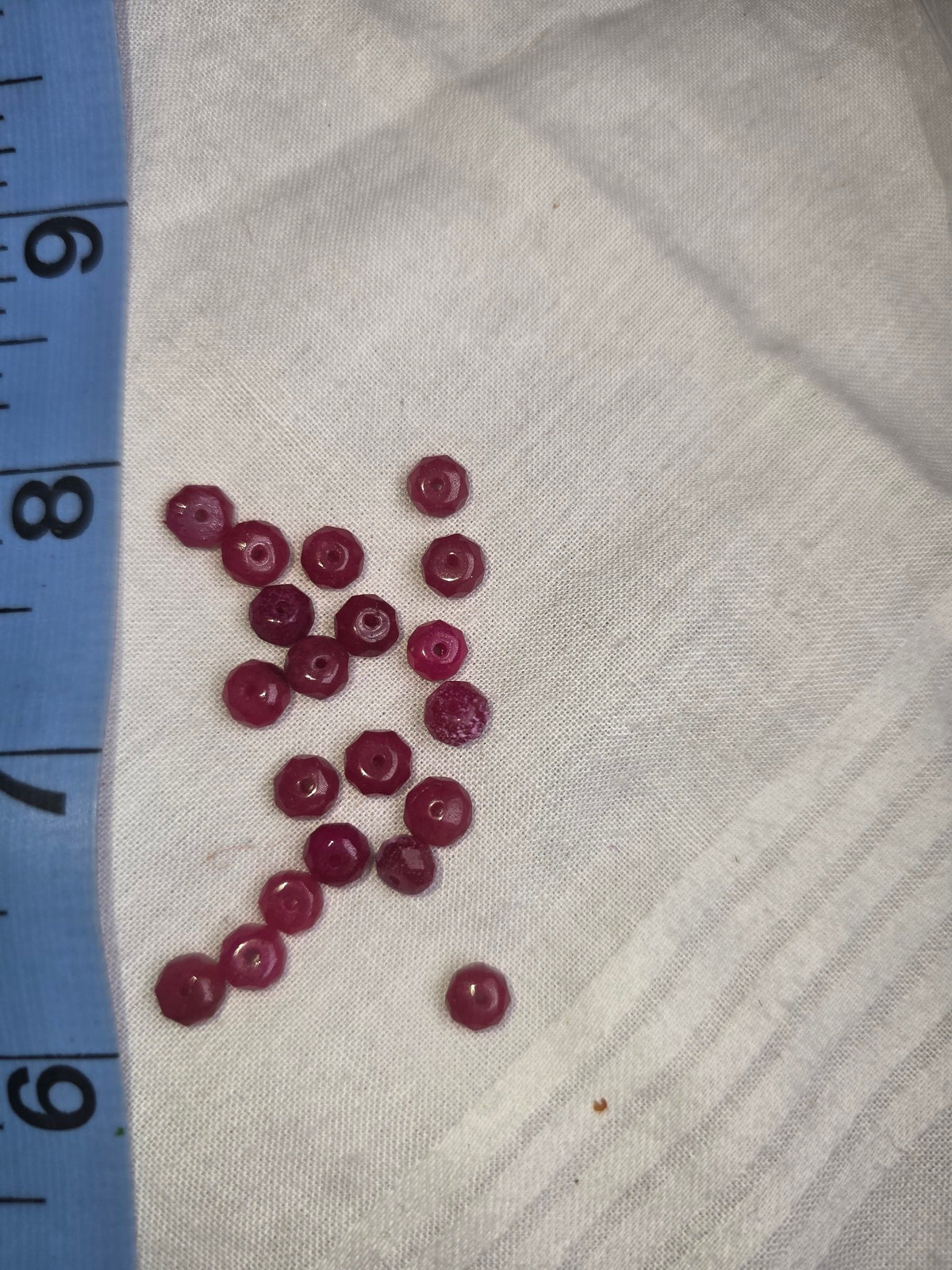 Raspberry red crystal faceted rondelle beads with ruler for scale