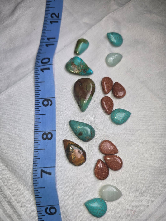 Mixed genuine turquoise, goldstone and pale stone teardrop beads with ruler for scale