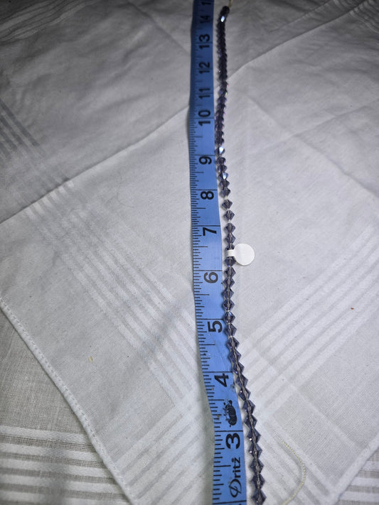 Dark purple crystal bicone bead strand with ruler for scale