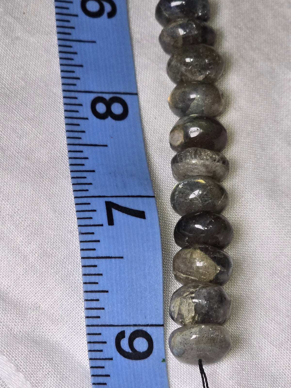 Closeup of labradorite rondelle beads showing grey colour and flash