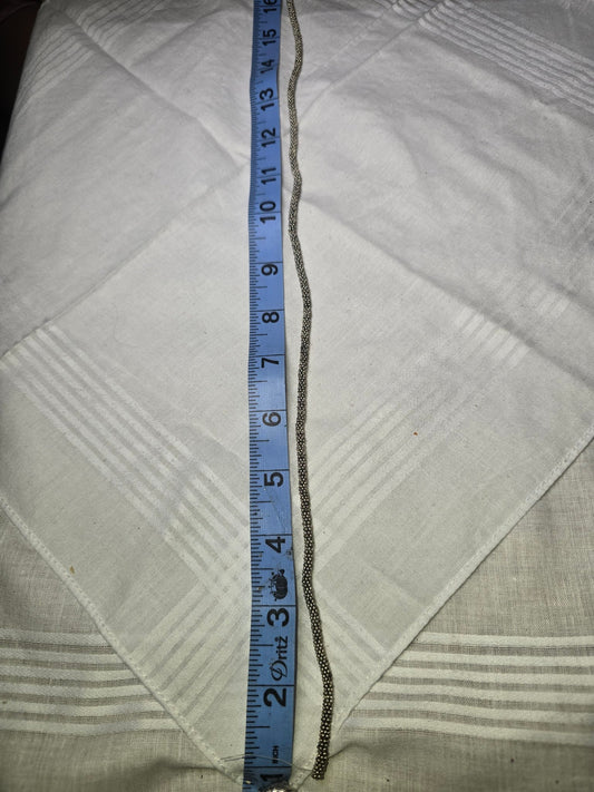 Silver spacer bead strand with ruler for scale