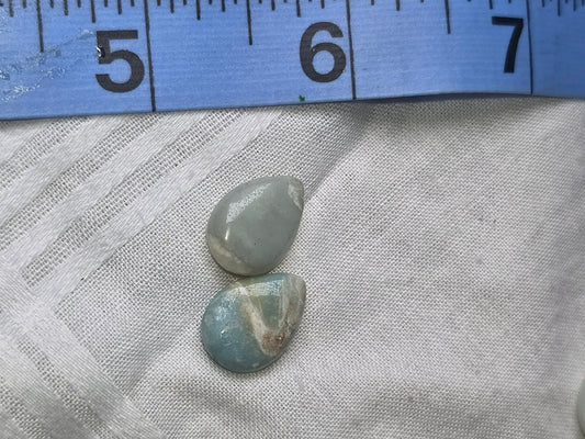 Pale blue teardrop beads closeup with ruler