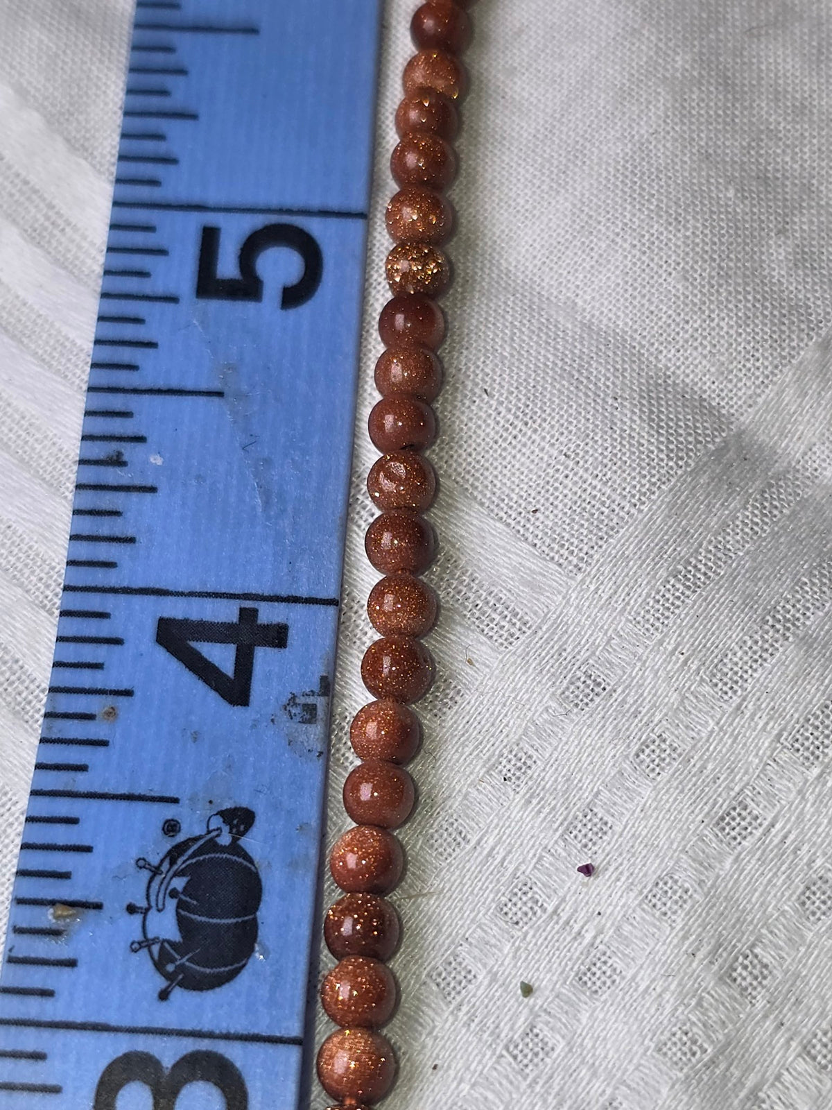 Goldstone round bead strand closeup