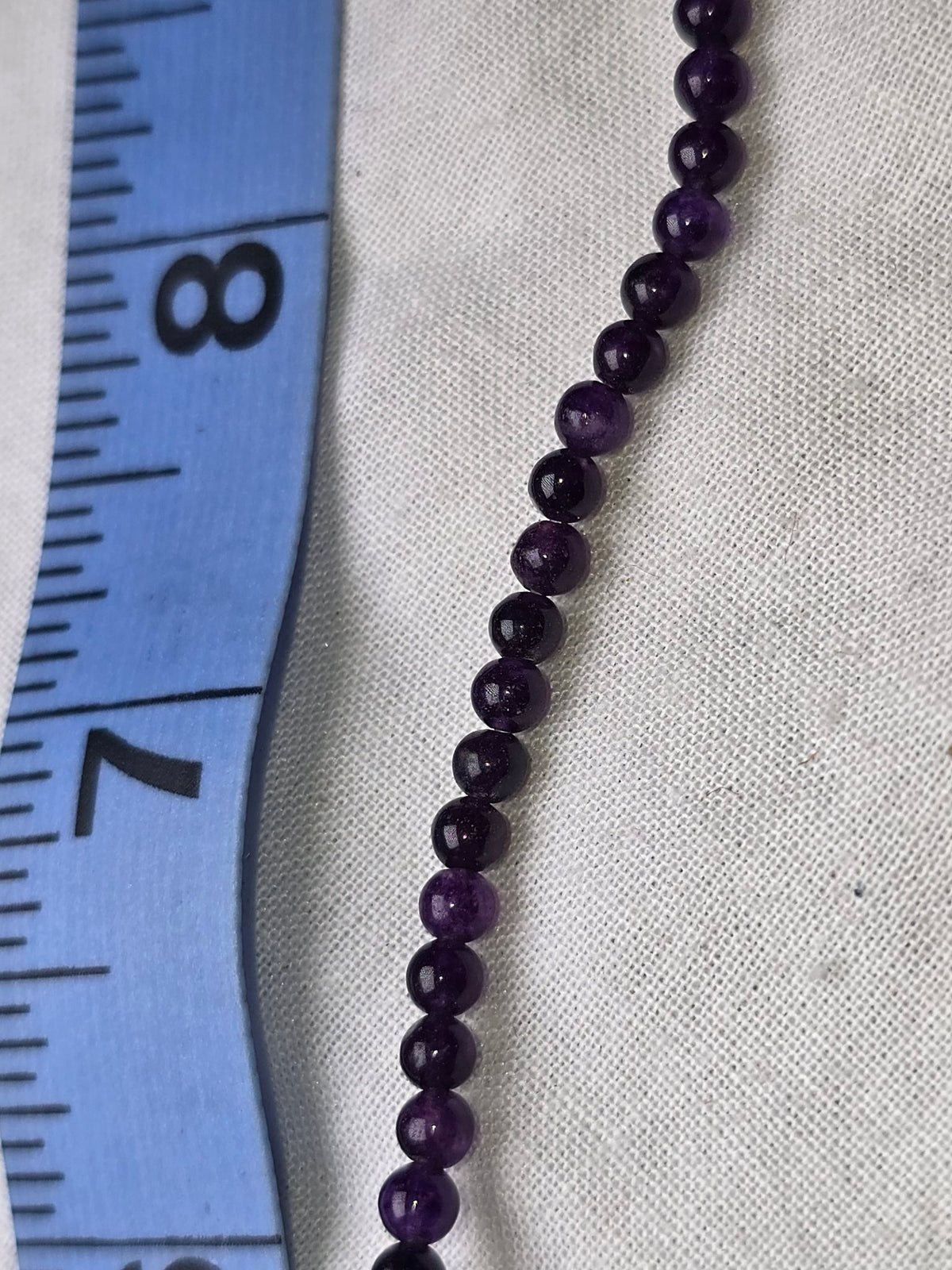 Amethyst round bead strand closeup