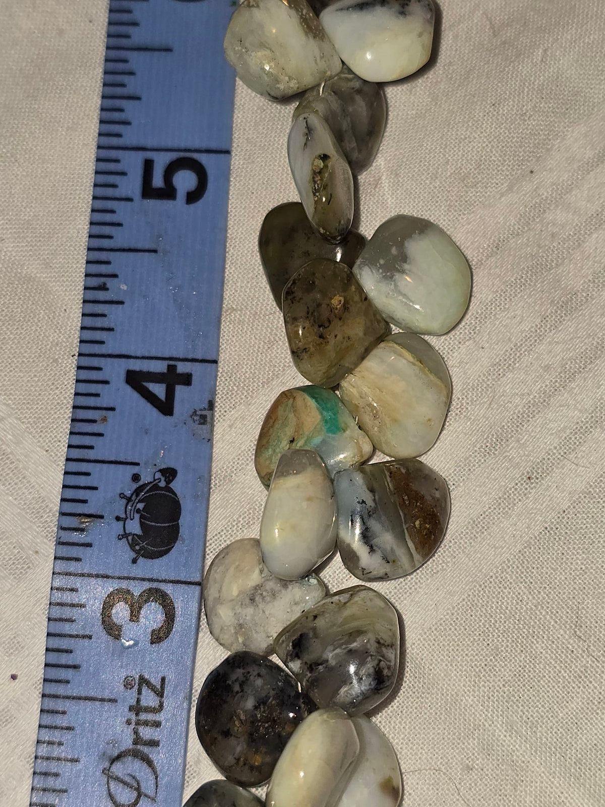 White mottled opal teardrop bead strand closeup