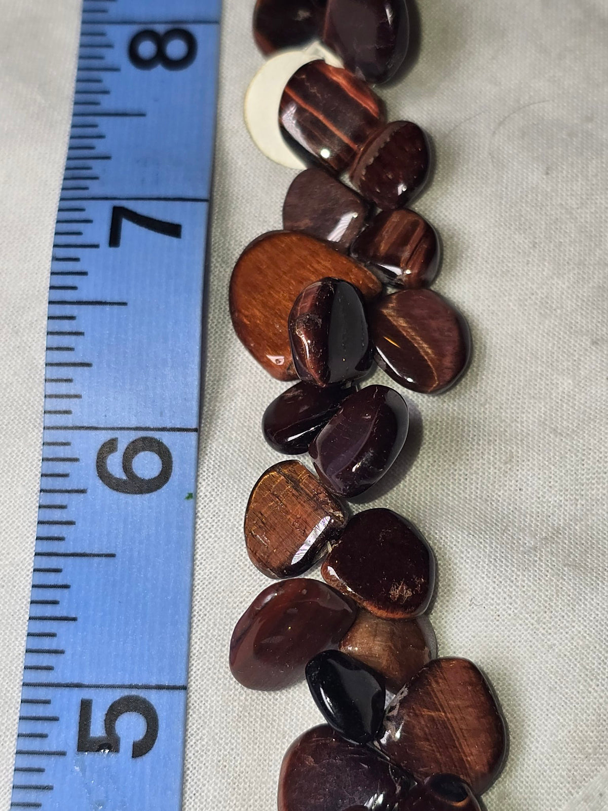 Brown tiger eye flat teardrop bead strand closeup