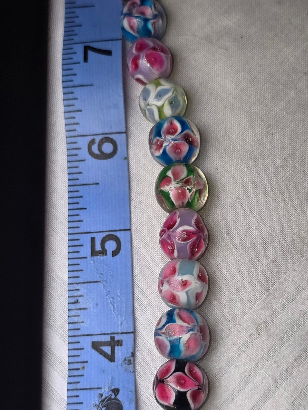 Floral lampwork glass round bead strand closeup