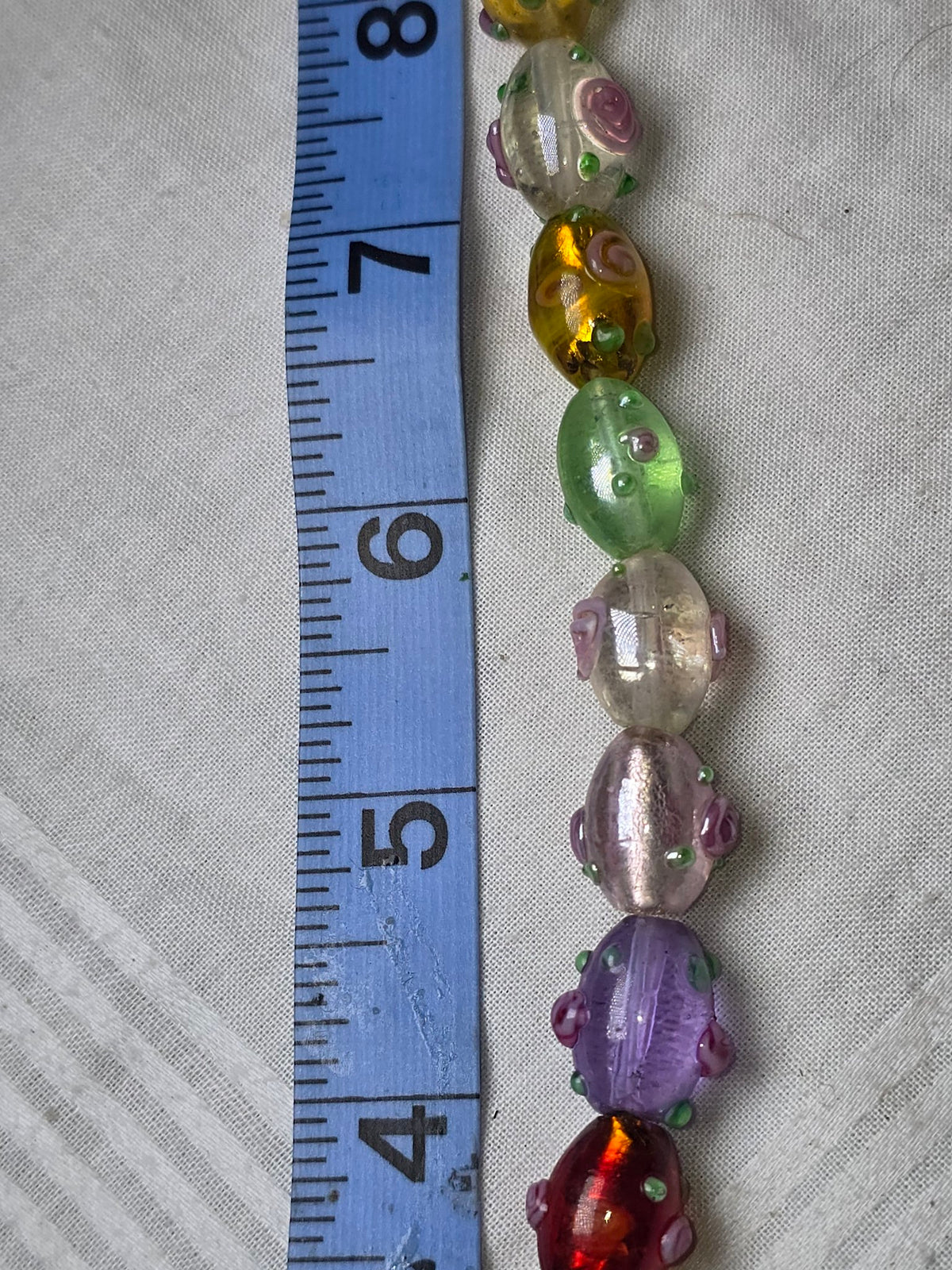 Multicolor lampwork glass oval bead strand closeup