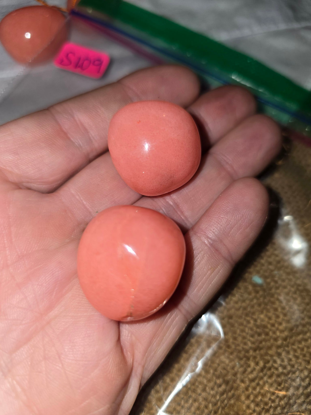 Salmon pink large oval bead hand closeup